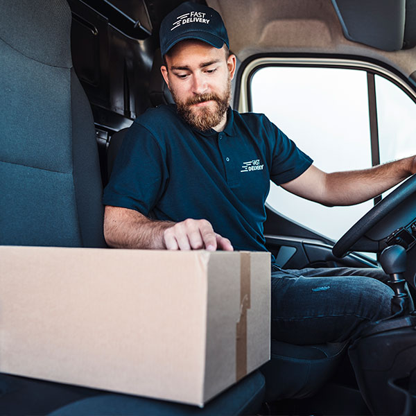 Delivery driver parked in vehicle for final mile parcel drop-off.